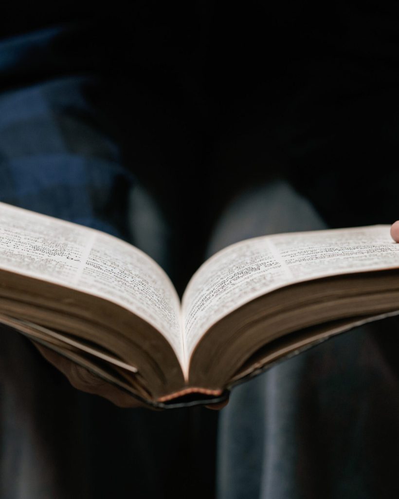 A young woman sits reading the Scriptures and prays during a Christian crisis to God. Prayer ideas for God's blessings for a better life female hands praying to god faith in good
